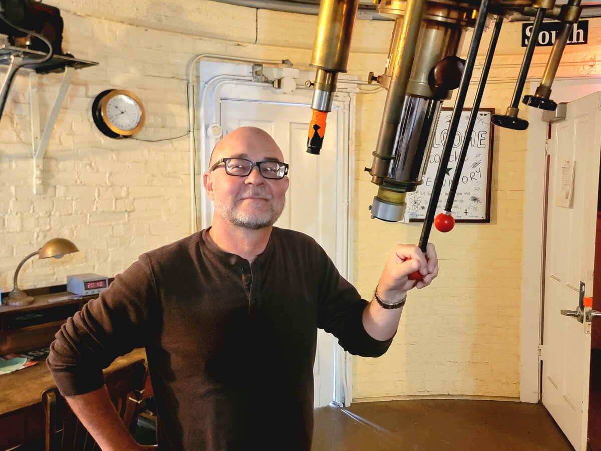 A man standing next to telescope instruments
