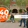 940 Feet with Decker French. Two people walking in front of brick building and people sitting on benches having a conversation.