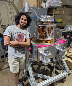 Suvinay Goyal standing next to a piece of equipment.